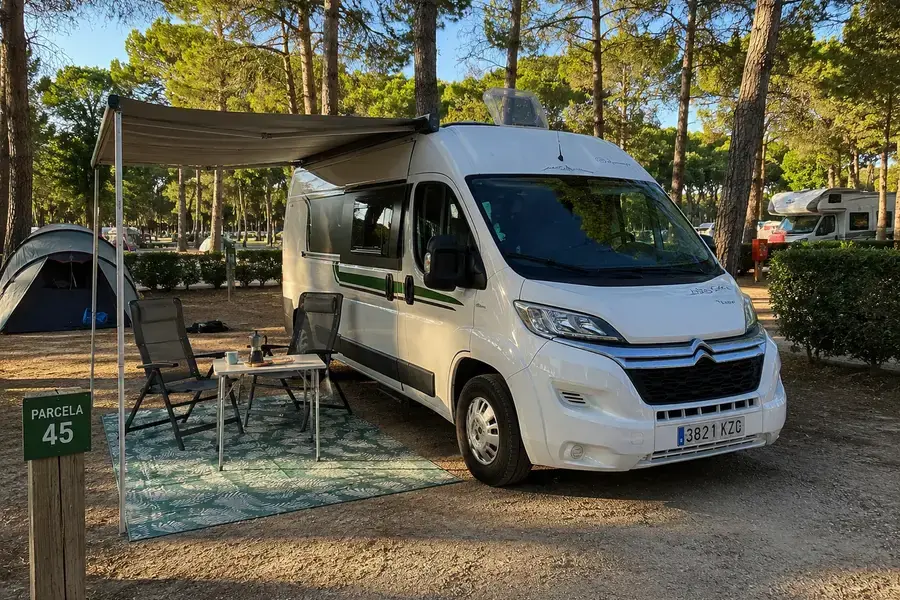 Camper en un camping bien equipado cerca de Madrid, con parcelas verdes y servicios