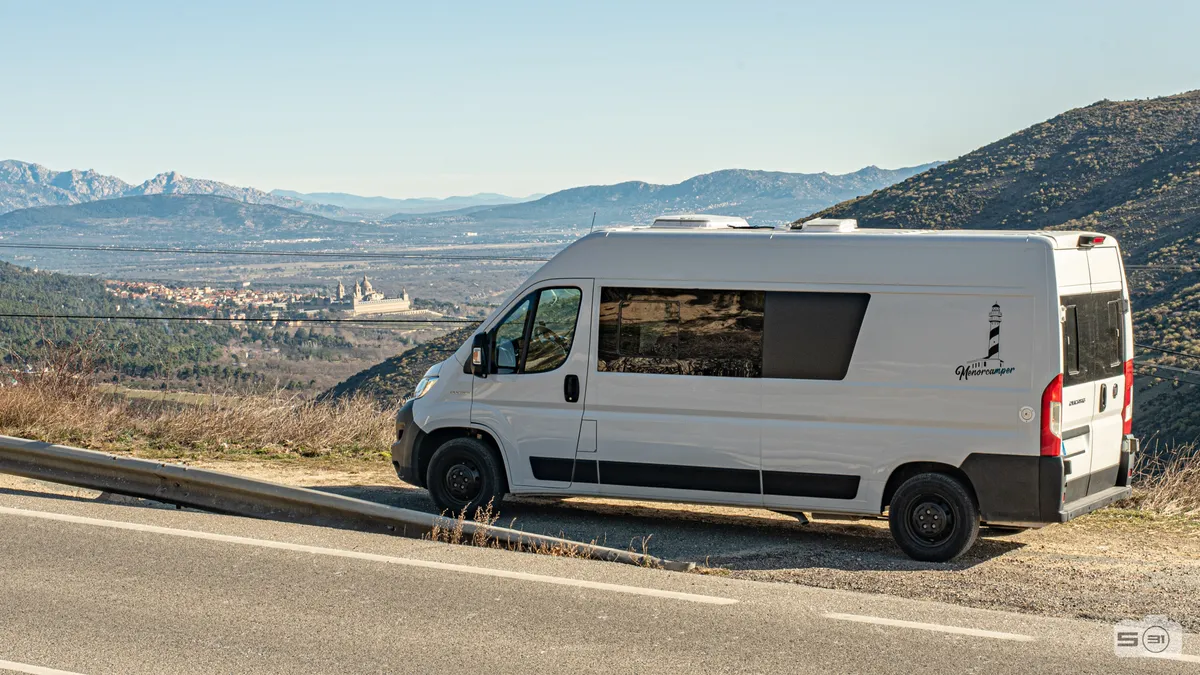 Camper de alquiler en la sierra de Madrid con el monasterio de El Escorial al fondo, primera etapa de la ruta por Europa