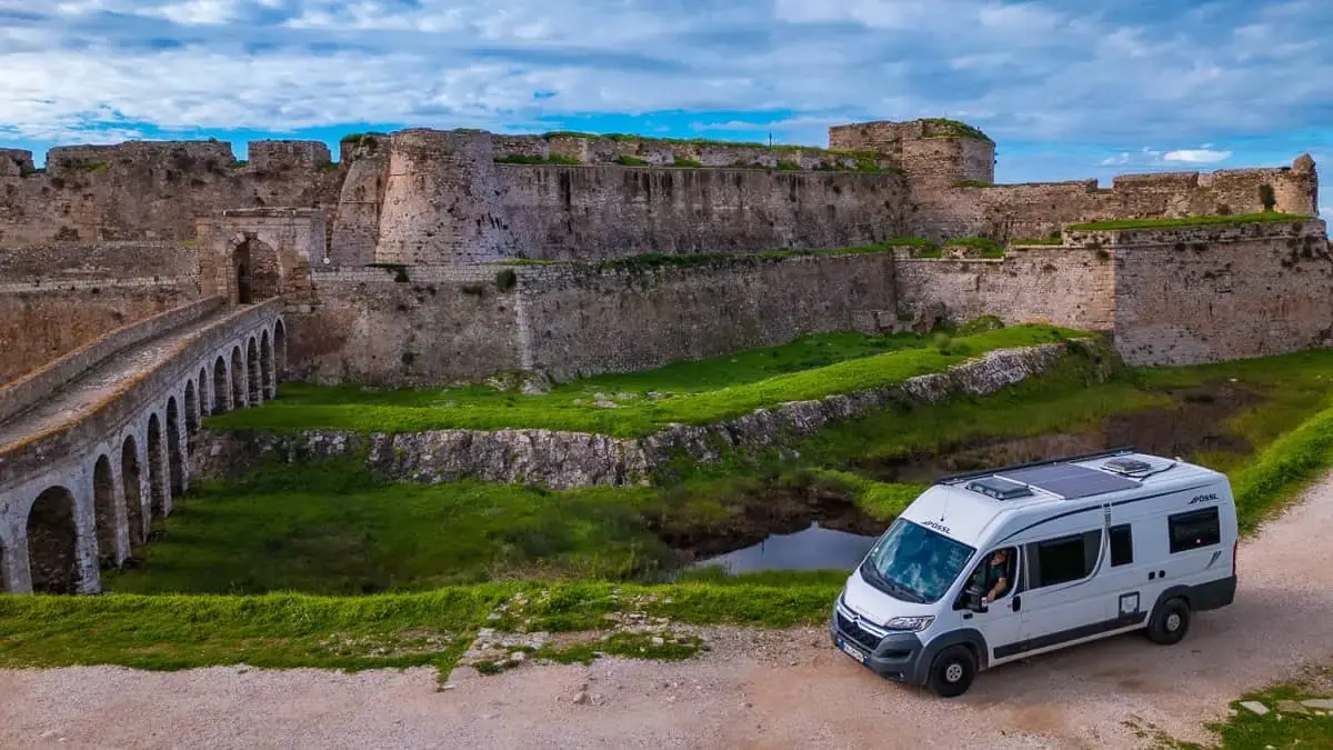Motorhome estacionada junto a una fortaleza medieval, una de las paradas de la ruta por Europa en casa rodante